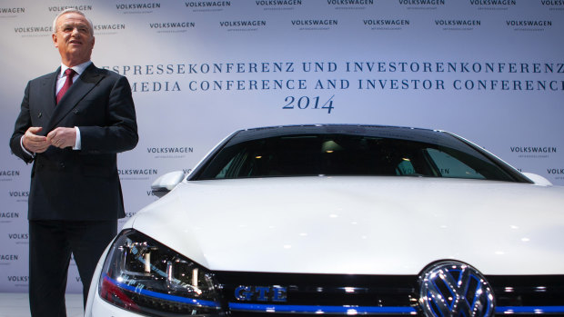 Martin Winterkorn poses beside a Volkswagen Golf GTE electric car in 2014.