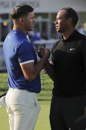 Separate ways: Brooks Koepka shakes hands with Tiger Woods after their second rounds.