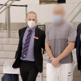 Benjamin Neil Pitt, right, is escorted through the arrivals hall at Sydney Airport after his extradition from Dubai.