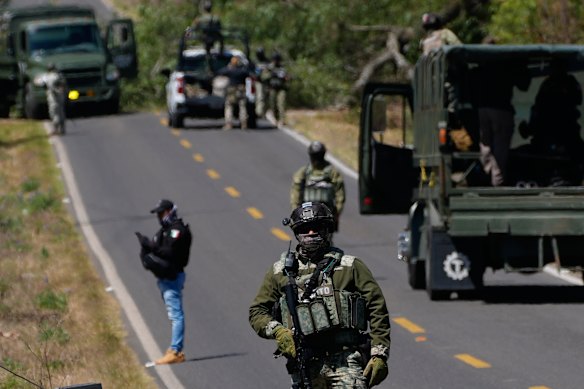 A soldier clears a roadblock near Tapalca, a day after violent reprisals by cartel members.