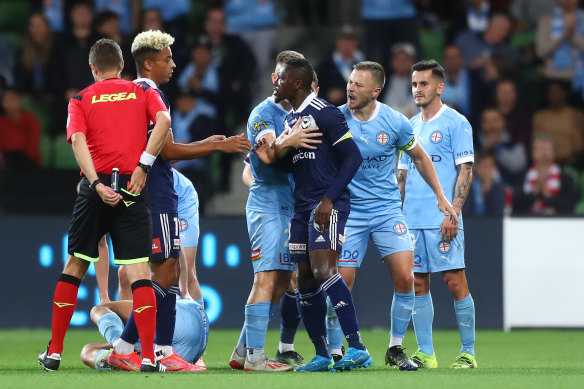Victory’s Adama Traore is held back by a City player after receiving his red card.