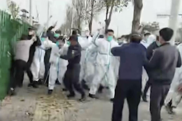 Security personnel attack a man during a protest at a Foxconn factory in Zhengzhou.