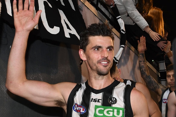 Scott Pendlebury of the Magpies high fives fans after Collingwood win the first qualifying final match against the Cats.