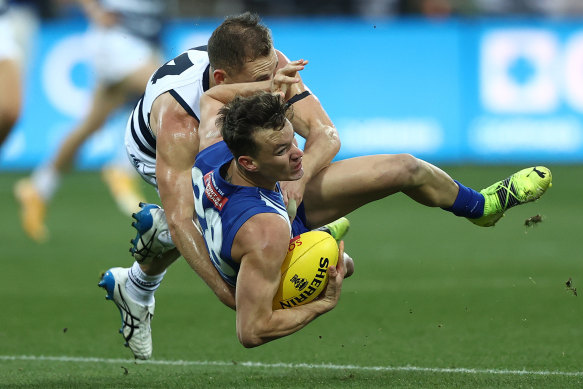 Joel Selwood throws everything at North’s Kayne Turner. 