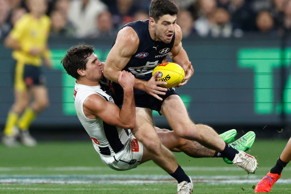 George Hewett of the Blues is tackled by Lachie Schultz of the Magpies.