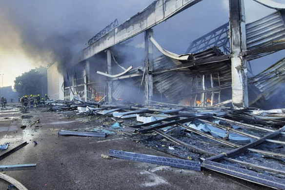 Firefighters work to extinguish a fire at a shopping centre burnt after a rocket attack in Kremenchuk.