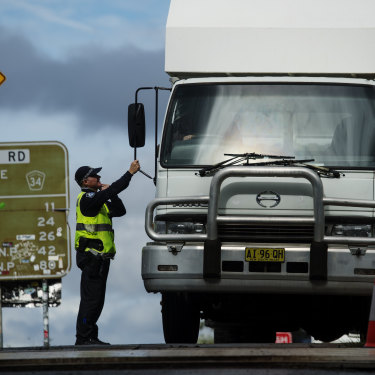 Police quizz a driver at a Queensland-NSW border checkpoint in the Gold Coast hinterland. 