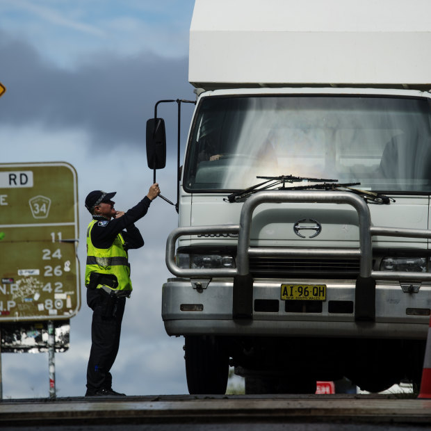 Police quizz a driver at a Queensland-NSW border checkpoint in the Gold Coast hinterland. 