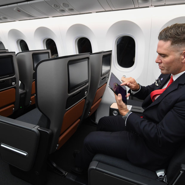 A cabin crew member takes a reaction test on an iPad onboard Qantas' long-haul test flight. 
