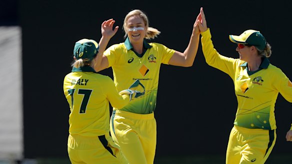 Ellyse Perry celebrates a wicket with Alyssa Healy (left) and Meg Lanning (right). 