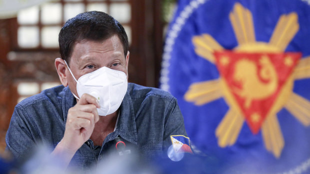Philippine President Rodrigo Duterte, wearing a mask, gestures during a meeting at the Malacanang presidential palace in Manila.