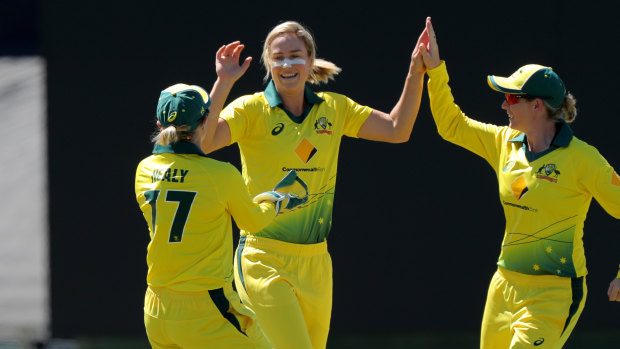 Ellyse Perry celebrates a wicket with Alyssa Healy (left) and Meg Lanning (right). 