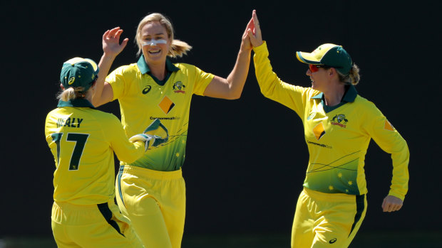 Ellyse Perry (centre) is congratulated by Alyssa Healy (left) and Beth Mooney. All will be missing from an exhibition match in India.