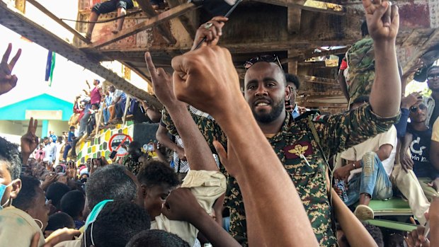 A Sudanese soldier protects protesters at a demonstration near the military headquarters.