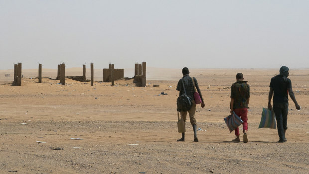 Three men head north towards Algeria after crossing the Assamaka border post in northern Niger on June 3.