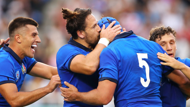 Michele Campagnaro of Italy kisses Dean Budd as he celebrates with teammates after scoring a try against Canada.