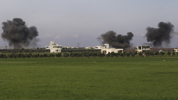 Columns of smoke rise up after air strikes hit the town of Saraqeb in Syria's Idlib province on Thursday.