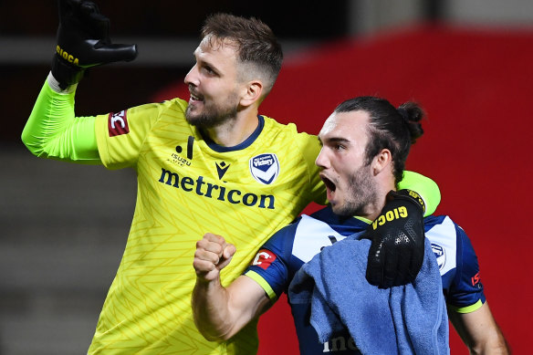 Victory goalkeeper Ivan Kelava and teammate Nick D’Agostino celebrate the win.