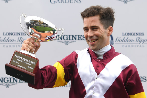  Adam Hyeronimus holds up the Vinery Stud Stakes trophy after Shout The Bar's victory.