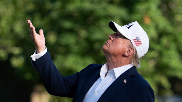 US President Donald Trump looks up at the American flag outside the White House on Sunday.