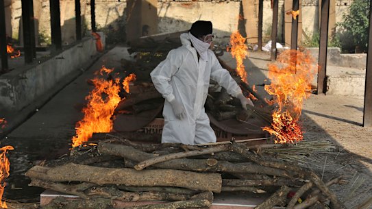 A family member performs the last rites of a COVID-19 victim in India.