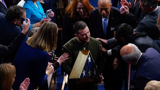 Ukrainian President Volodymyr Zelensky holds an American flag that was gifted to him by House Speaker Nancy Pelosi of Calif., as he leaves after addressing a joint meeting of Congress in Washington on Thursday.