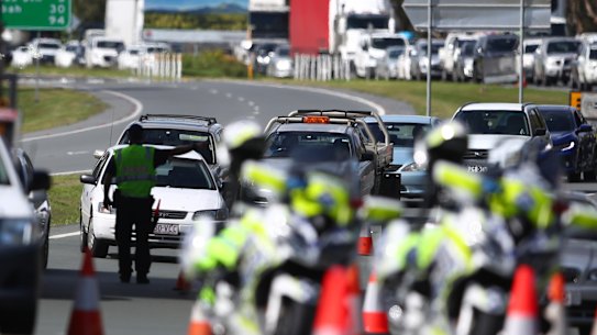 GOLD COAST, AUSTRALIA - MARCH 26: Queensland Police stop vehicles at a Police checkpoint set up at the Queensland and New South Wales border in Coolangatta on March 26, 2020 on the Gold Coast, Australia. Queensland borders have been shut down since midnight in response to the COVID-19 pandemic. Interstate visitors will be turned back, while any Queensland residents returning from other states or territories must now self-isolate for 14 days unless they are an exempt person travelling for freight or other essential travel. There are now 2676 confirmed cases of COVID-19 in Australia and the death toll stands at 11. (Photo by Chris Hyde/Getty Images)