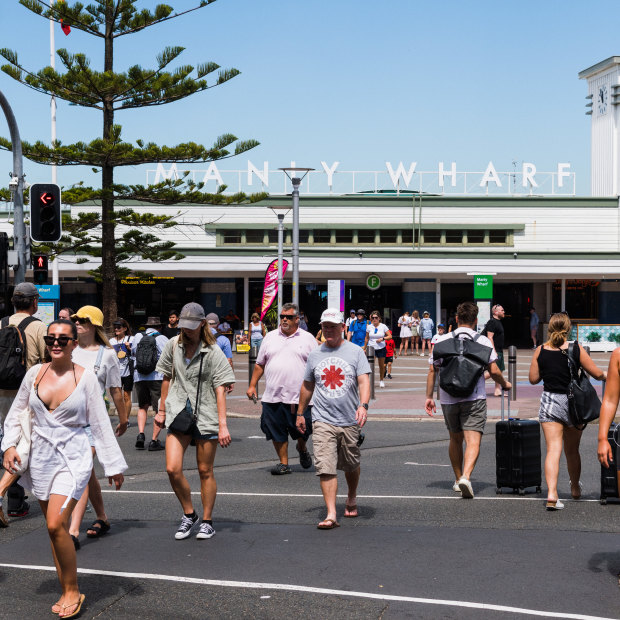 Pedestrians cross the road at Manly wharf.
