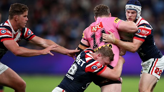 Liam Martin is tackled by Luke Keary and Drew Hutchison of the Roosters. 