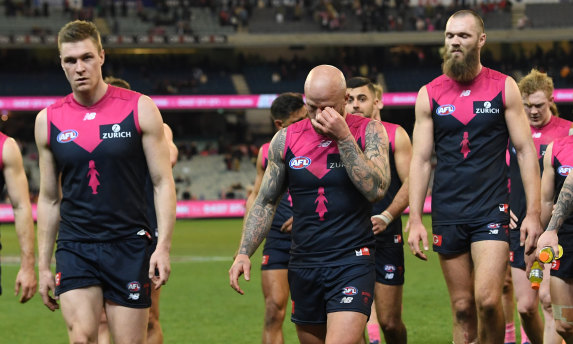 The dejected Dees walk off the MCG on Sunday.