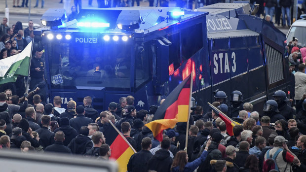 A police water cannon stands between far-right demonstrators in Chemnitz, eastern Germany, on Saturday.