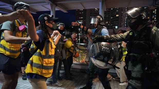 Church volunteers wearing vests that say 'protect the children' block policemen who arrived at Tung Chung to arrest protesters.