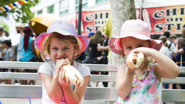 Olivia Shields, 6, and Isabelle Shields, 4, enjoy a German hotdog.