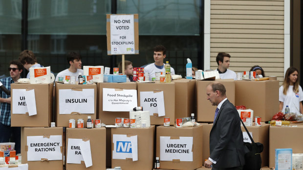 Anti-Brexit activists protest as they deliver a pile of medical supplies in cardboard boxes to the Department of Health and Social Care in London. 