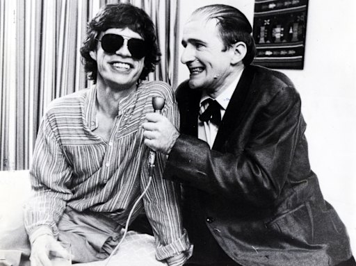 Norman Gunston (Garry McDonald) shares a bedside chat with Mick Jagger.