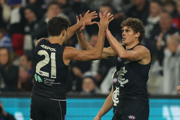 Curnow celebrates a goal with Carlton teammate Jack Martin.