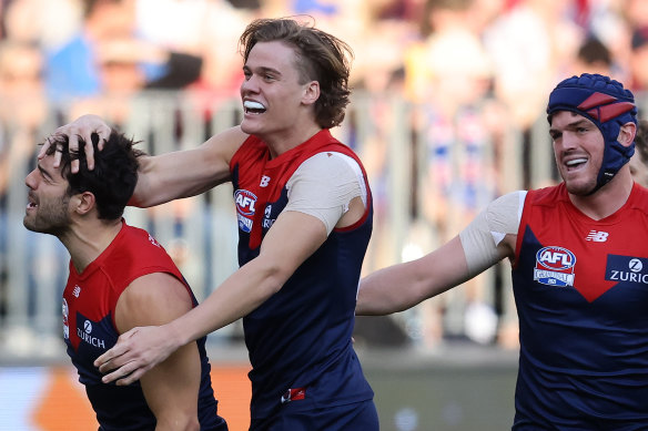 Christian Petracca celebrates with teammates after a grand final goal.