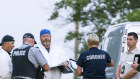 Investigators gather in front of the scene of a stabbing in Weldon, Saskatchewan.