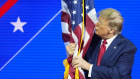Donald Trump hugs and kisses the American flag at the Conservative Political Action Conference.