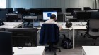 A worker at a desk in an underused office in London.
