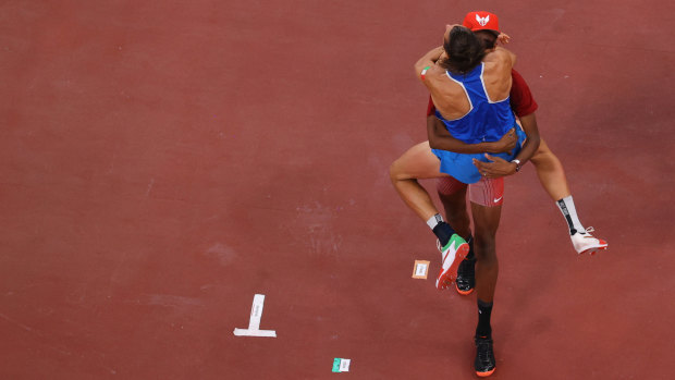 Gianmarco Tamberi of Italy and Mutaz Essa Barshim of Qatar react after both winning the gold medal in the men’s high jump.