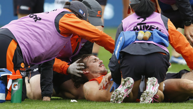 Knocked out: Giants co-captain Phil Davis receives medical attention before being helped from Spotless Stadium.