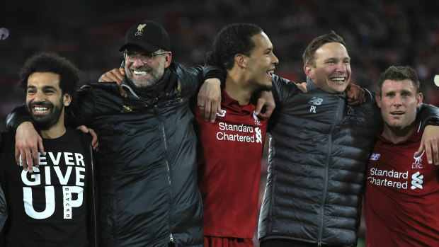 Jurgen Klopp (second from left) celebrates Liverpool's win with his players and staff.