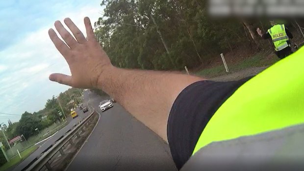 The senior constable signalled at the car to stop. 