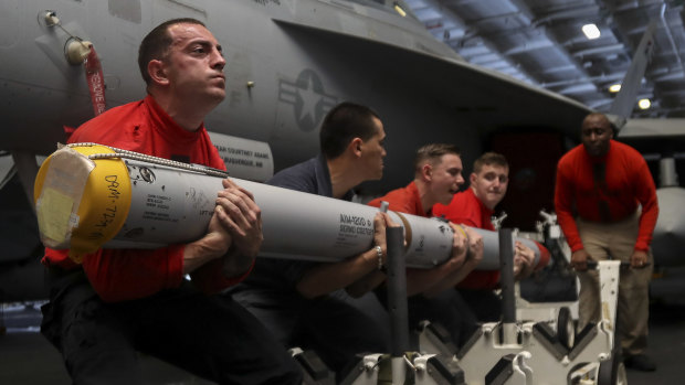 Aviation ordnance men transport a missile aboard the Nimitz-class aircraft carrier USS Abraham Lincoln. The aircraft carrier strike group is being deployed to the Persian Gulf to counter an alleged but still-unspecified threat from Iran.