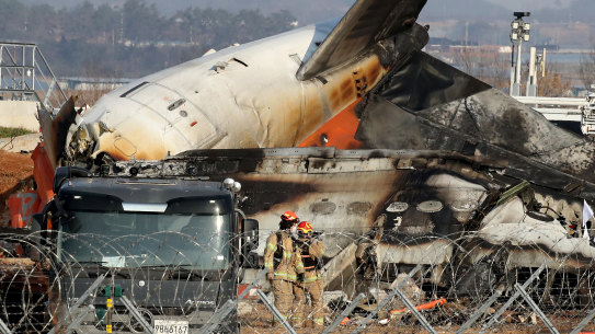 Firefighters and rescue teams work at the wreckage of a passenger plane at Muan International Airport in Muan-gun, South Korea.