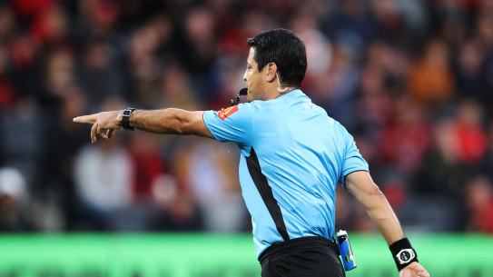 Referee Alireza Faghani points to the penalty spot after reviewing a hand-ball with VAR earlier this season.