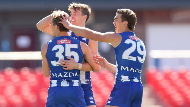 Charlie Lazzaro of North Melbourne celebrates his goal with teammates. 