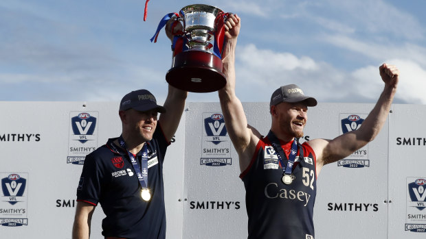 Casey coach Mark Corrigan and skipper Mitch White hold the premiership cup aloft.