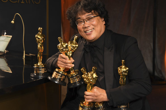 Bong Joon-ho holds the Oscars for best original screenplay, best international feature film, best directing and best picture.